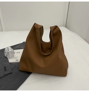 Detailed view of the brown wrinkled leather texture on a large minimalist tote bag