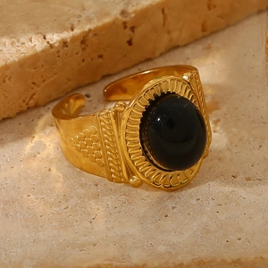 Detailed close-up of a vintage gold open ring featuring a large oval black natural stone