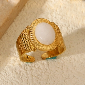 Detailed macro view of vintage gold stainless steel ring with white natural stone inlay