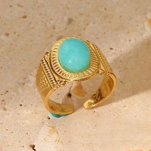 Macro view of a gold-tone stainless steel ring featuring a turquoise stone and carved details