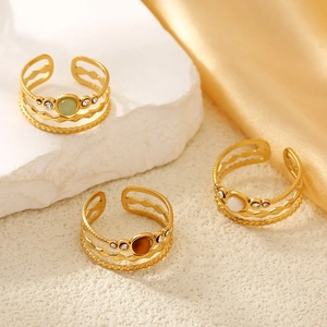 Detailed close-up of three gold-plated hollow rings with natural stones and tiny zircons