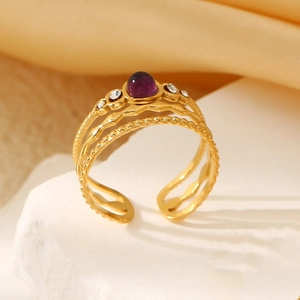 Detail of vintage gold-plated titanium steel ring with purple stone and micro diamonds
