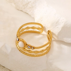 Detail of bohemian gold ring with white stone inlay and sparkling zircon accents