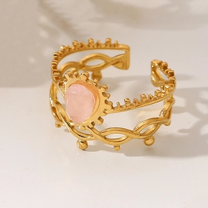 Detail of 18k gold plated double-layer ring with drop-shaped pink stone and sun pattern