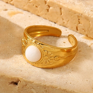 Macro detail of 18K gold-plated ring featuring sun flower relief and white gemstone inlay