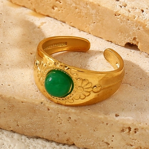 Macro detail of 18K gold-plated vintage ring with green stone on stone base