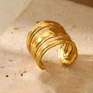 Detail of gold triple-layered open ring with hammered texture on a stone base