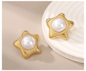 Detailed close-up of 18k gold star earrings with hammered texture and faux pearls