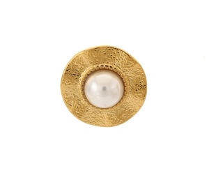 Detail of 18k gold earrings showing a white pearl inlay on hammered metal surface