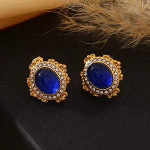 Détail de boucles d'oreilles vintage avec pierre bleue et bordure en cristaux