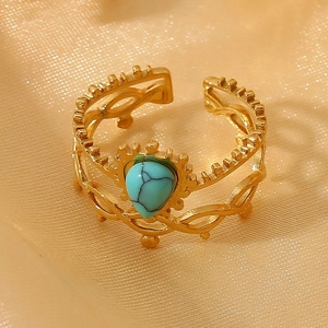 Vintage gold crown ring with a teardrop turquoise stone on champagne velvet