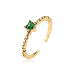 Detail of gold-plated open ring with heart green zircon and retro engraved texture
