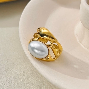 Detailed macro view of an irregular gold ring featuring a large white oval pearl inlay