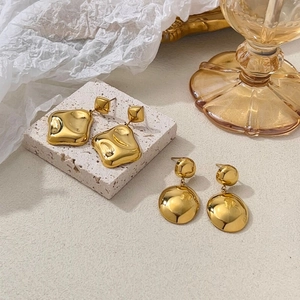 Chic gold-plated geometric earrings with polished mirror finish on stone background
