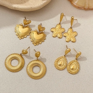 Close-up of vintage gold earrings set with detailed textures and embossed patterns