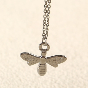 Macro shot of silver sunflower bee pendant with fine wing textures and polished finish