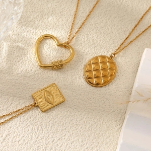 Colliers dorés avec pendentifs cœur et œil sur fond texturé élégant de haute qualité