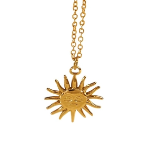 Golden sunface pendant necklace in minimalist vintage style on white background