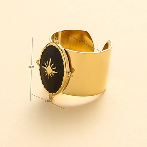 Macro shot of gold-plated bangle featuring a sun totem on black stone with dimensions