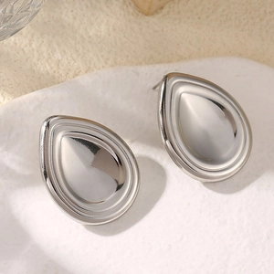 Détail macro de boucles d'oreilles gouttes argentées avec finition miroir poli éclatant
