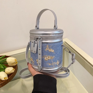 Sac seau cylindrique en jean bleu avec broderies florales et détails en cuir argenté