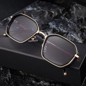 Men's retro punk square sunglasses with black and gold octagonal frame on rock texture