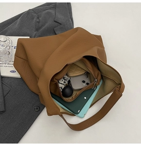 Top view of large brown leather tote bag interior showing spacious storage and items