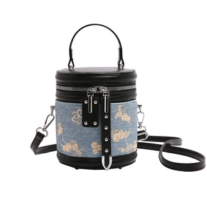 Blue denim bucket bag with gold floral embroidery and black leather trim for women