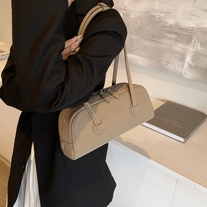 Minimalist taupe leather tote bag with long handles and sleek double zipper closure