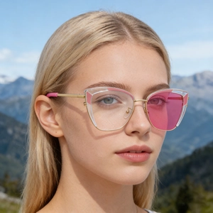 Close-up of cat-eye sunglasses with asymmetric pink and clear lenses on gold metal frame