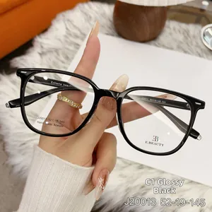 Detail of glossy black acetate square eyeglass frames with silver hinge accents
