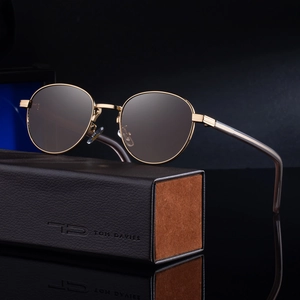 Retro oval sunglasses with gold metal frame and brown lenses next to leather case