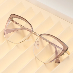Fashion cat eye sunglasses with champagne frames and gold metal accents on beige podium