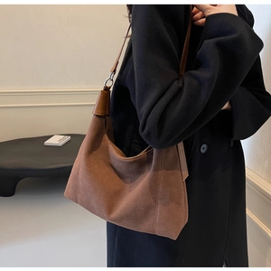 Vue détaillée du grand sac hobo en daim marron avec anneaux argentés et bandoulière