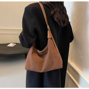 Détail du grand sac cabas en daim marron avec bandoulière en cuir et texture gaufrée
