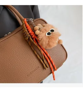Detail des CHERIMATE-Logos auf brauner Lederhandtasche mit plüschigem Bären-Anhänger
