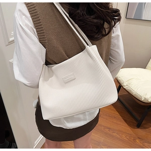 Detail of white pleated tote bag showing the fine texture and fashion brand label