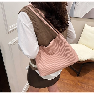 Close-up of pink pleated tote bag with leather straps and Fashion & Bags logo patch