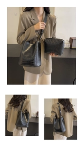 Detail of black crocodile texture bucket bag and matching pouch in a two-piece set