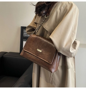 Detail shot of the vintage brown crossbody bag with distressed leather texture and chain strap