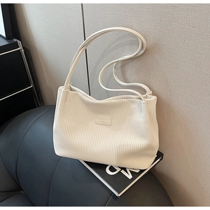 Detail of off-white corduroy bucket bag texture with embroidered fashion bags label