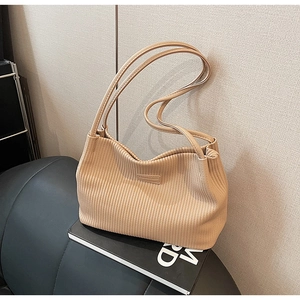 Close-up of beige pleated bucket bag texture with double straps on minimalist background