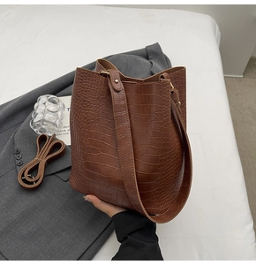 Close-up of brown crocodile pattern texture on a large capacity bucket bag with shoulder strap