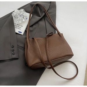 Detail of dark brown pleated bucket bag textured material with adjustable straps
