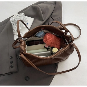 Top view of large capacity brown pleated bucket bag interior showing daily essentials