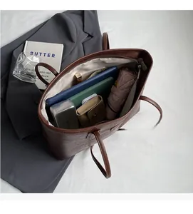 Interior view of brown leather tote bag showing space for tablet, notebook, and umbrella
