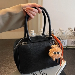 Chic black litchi pattern leather bowling bag with cute brown monster plush charm