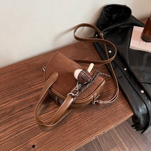 Detail of vintage brown suede crossbody bag featuring ZIANDI logo and baseball charm
