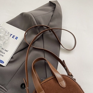 Close-up of brown matte suede and smooth leather splicing crossbody bag with metal zipper
