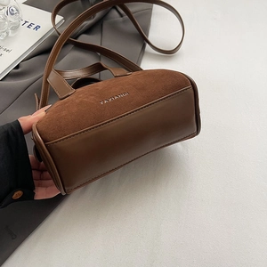 Detail of vintage brown textured Boston bag with stitching and brand logo